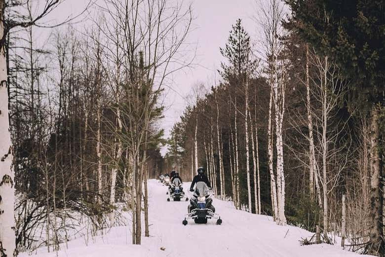 Paseo en moto de nieve bajo la aurora boreal