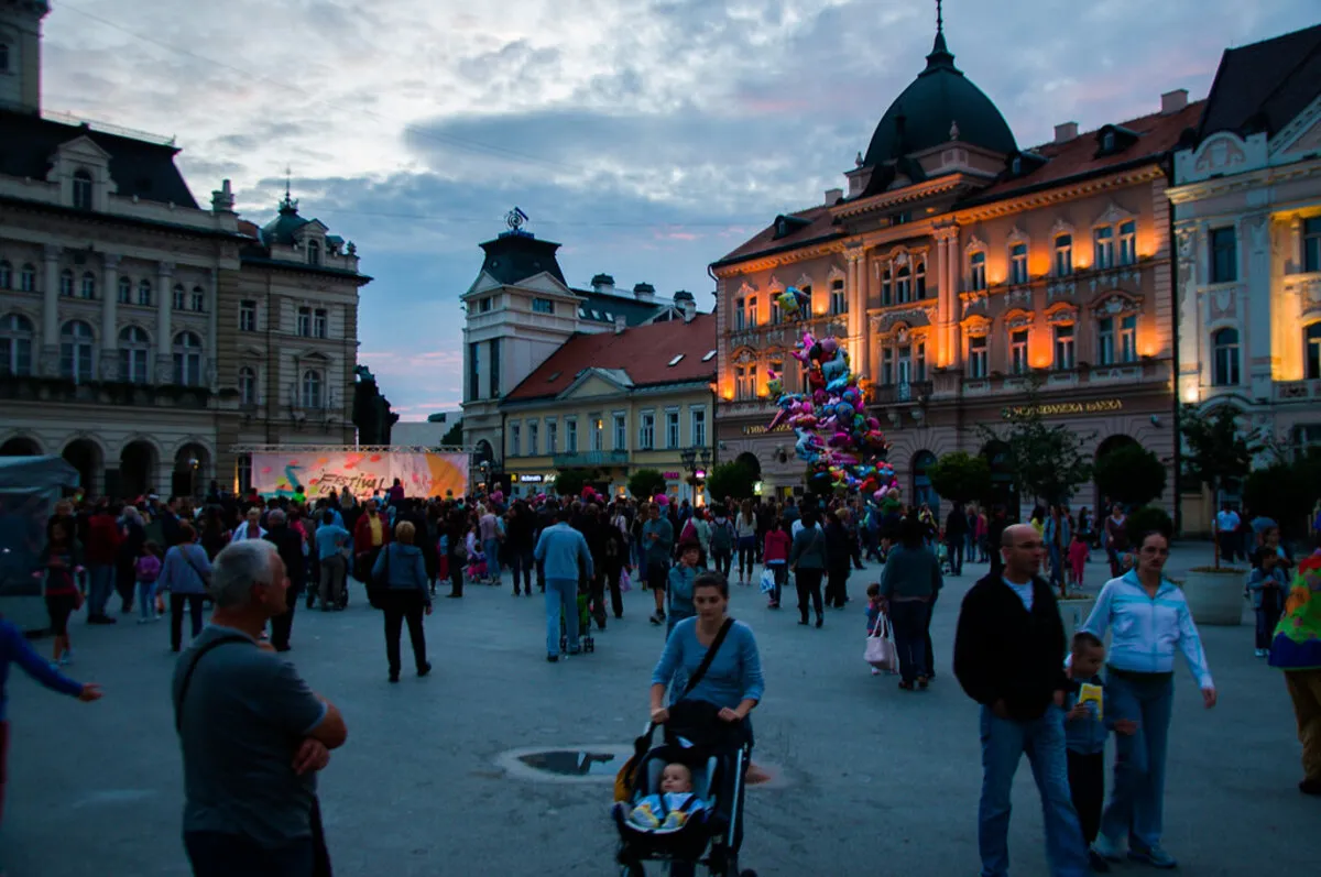 El centro de la ciudad de Novi Sad. Una plaza repleta de gente con varios edificios históricos al fondo