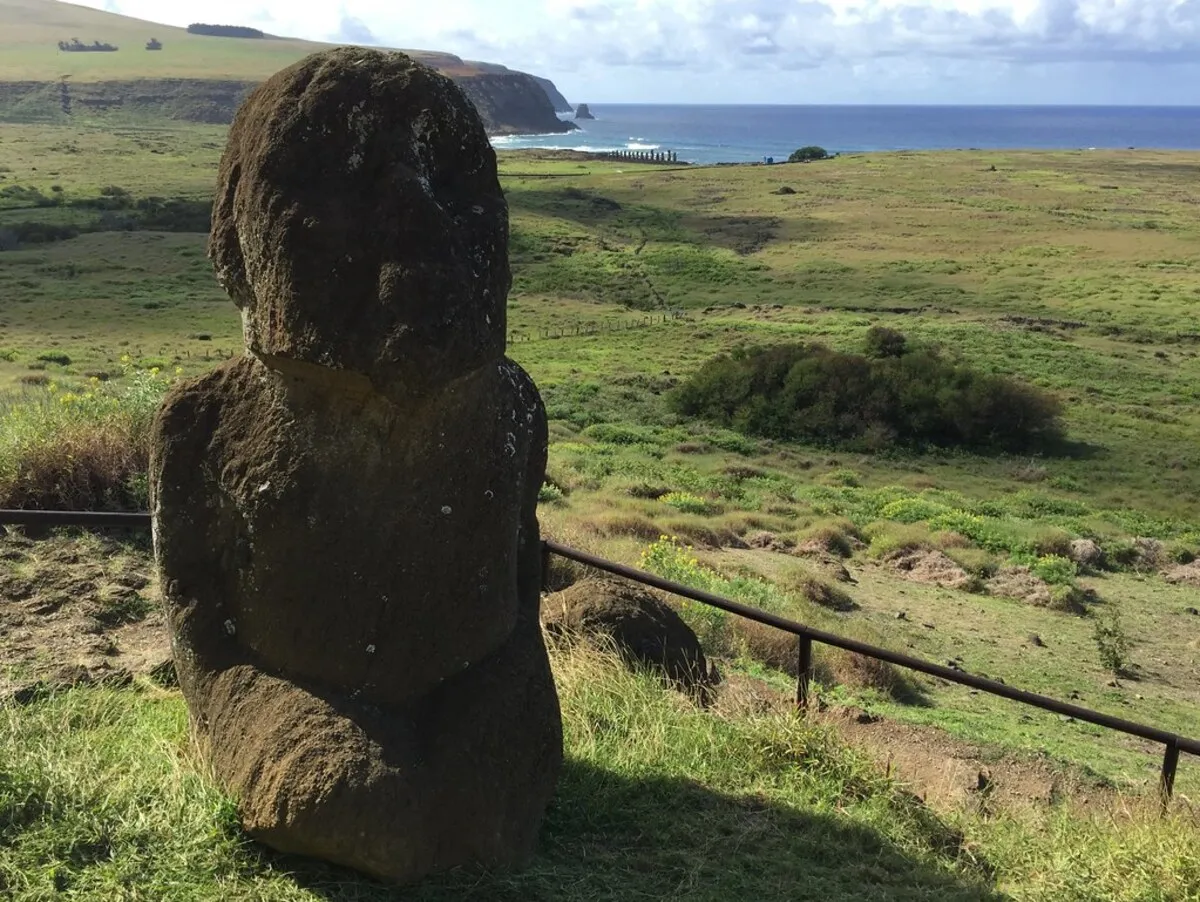 Tukuturi Moai una de las figuras que se encuentra en medio de la vegetación y con el mar al fondo