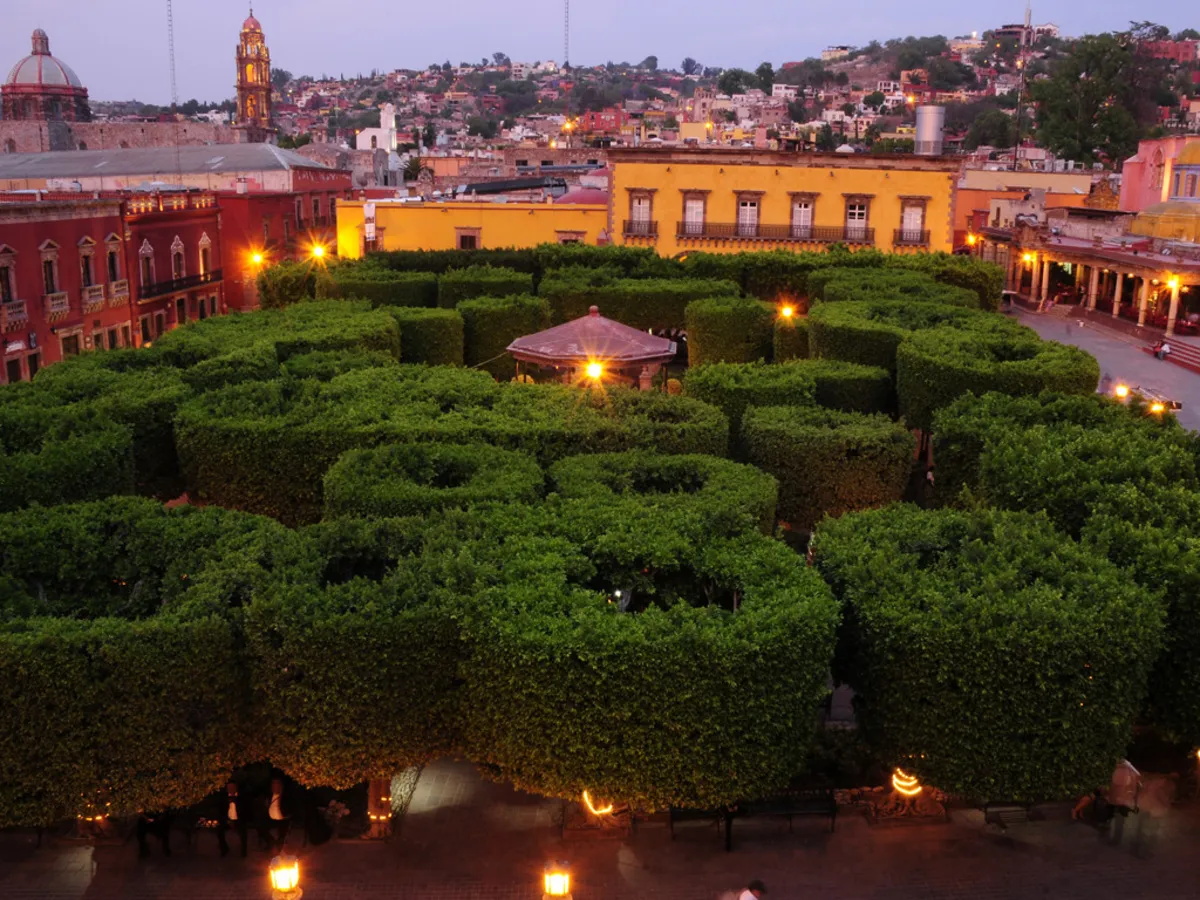 El Jardin Principal de la ciudad durante la el atardecer con las luces encendidas