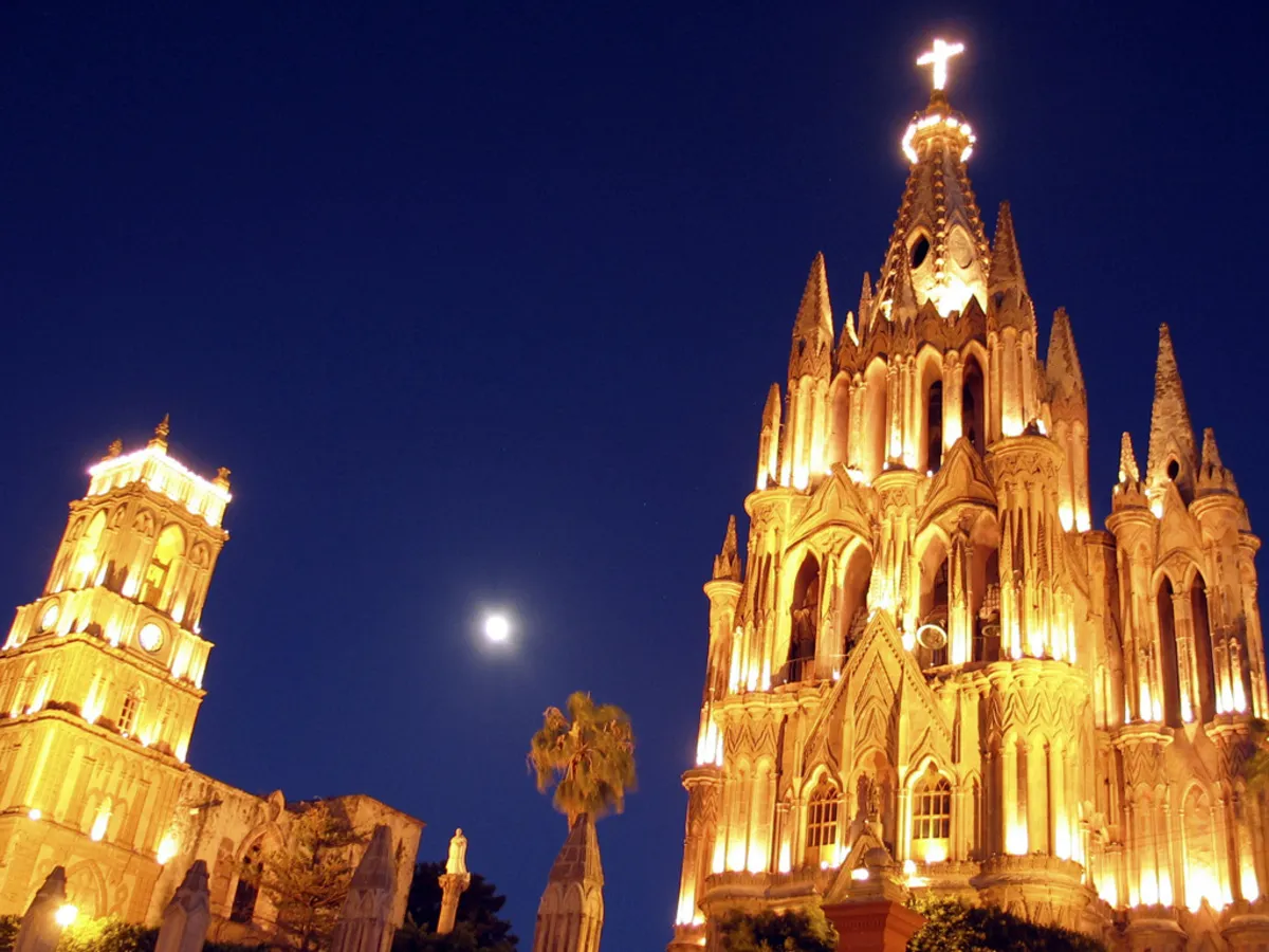 La fachada principal de la parroquia durante la noche ya que está todo iluminada