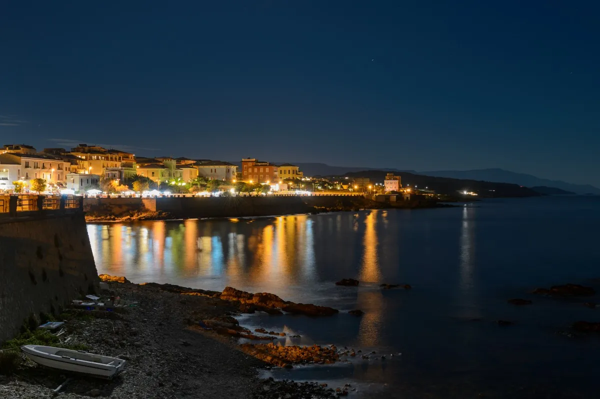 La ciudad de Alghero desde el puerto de noche