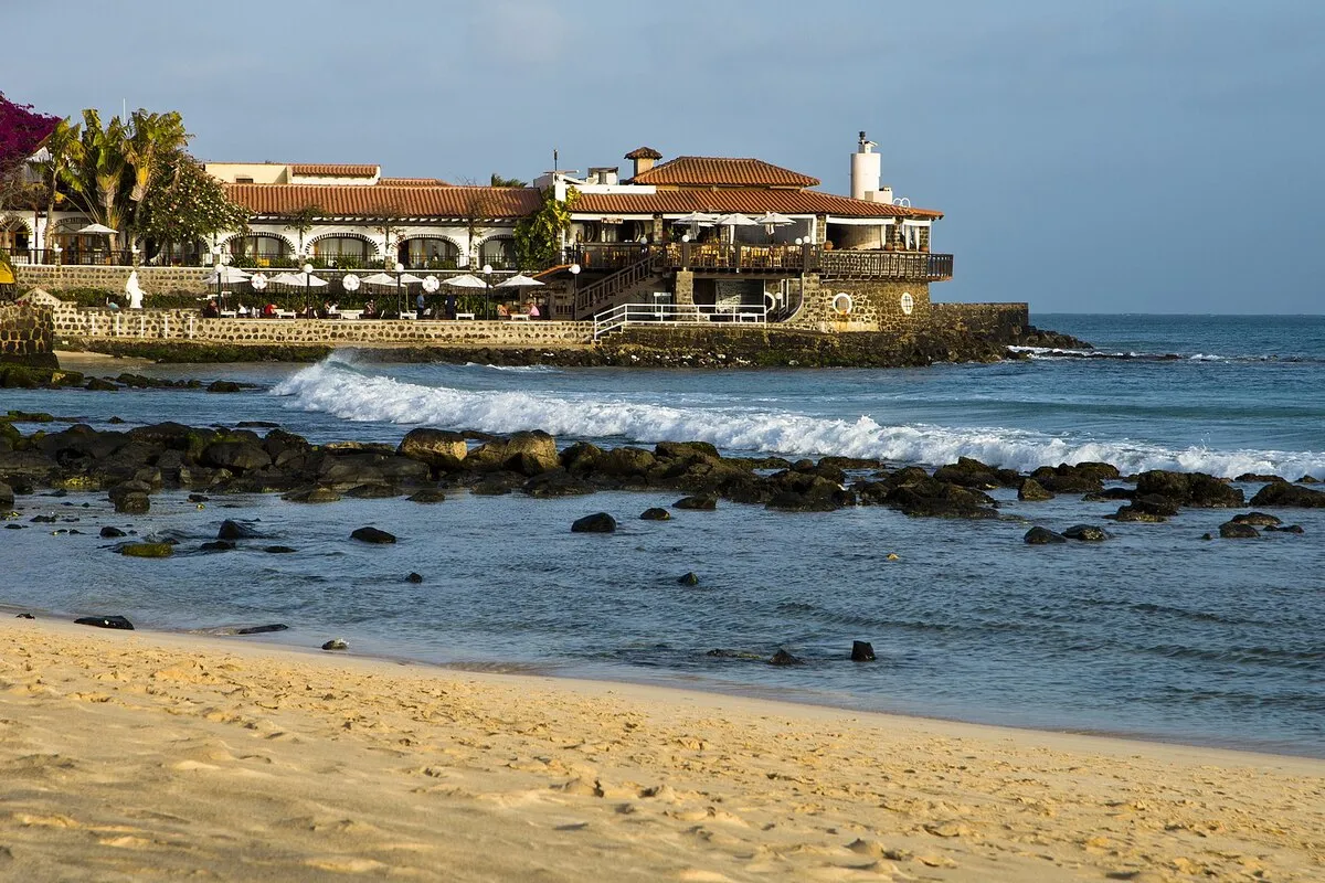 Preciosas vistas desde la playa del paseo marítimo, restaurantes y un faro en el fondo