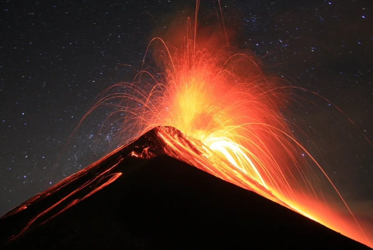 Volcán en plena erupción soltando mucho humo por el crater