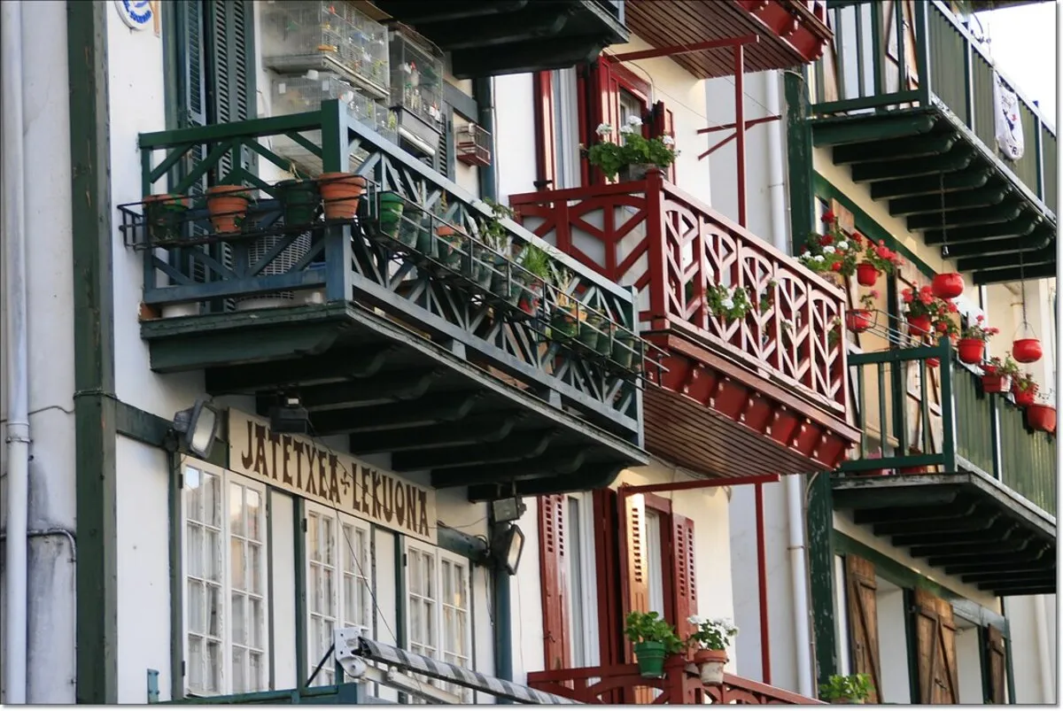 Los famosos balcones de colores llenos macetas con geranios.