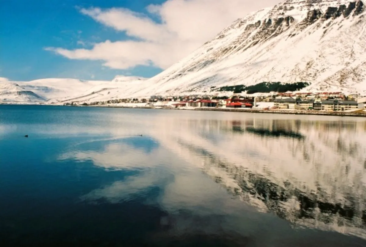 Montaña repleta de nieve reflejada en el oceano