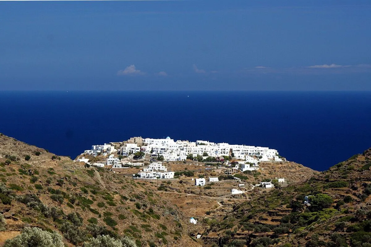 Panorámica del pueblo blanco de la isla de Sfinos en un monte y con el mar de fondo