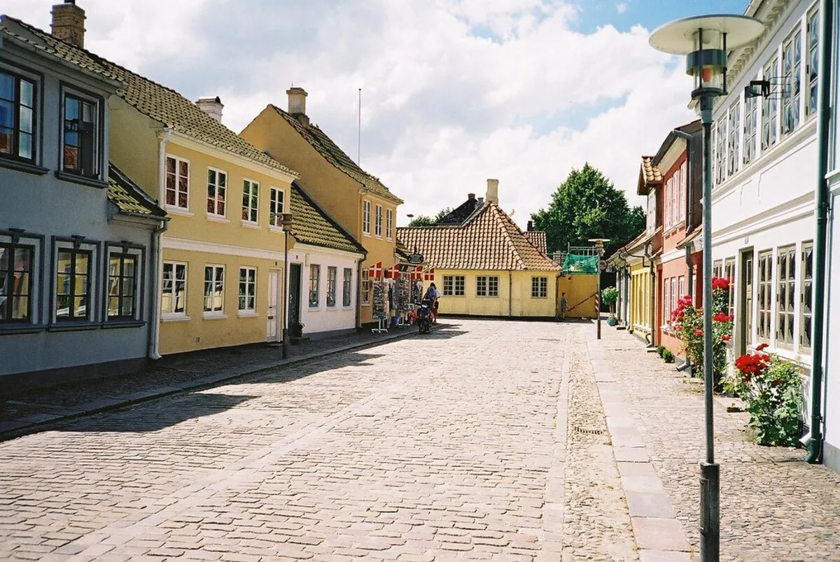 Una de las calles principales de Odense con casa de colores y puesto de suvenirs durante un día soleado