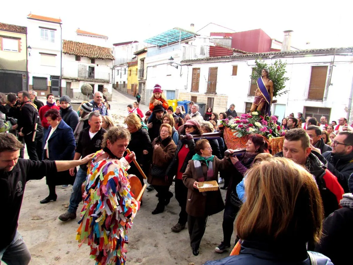 Gente del pueblo Piornal sujetando al cristo y rodeando al Jarramplas en medio de las fiestas