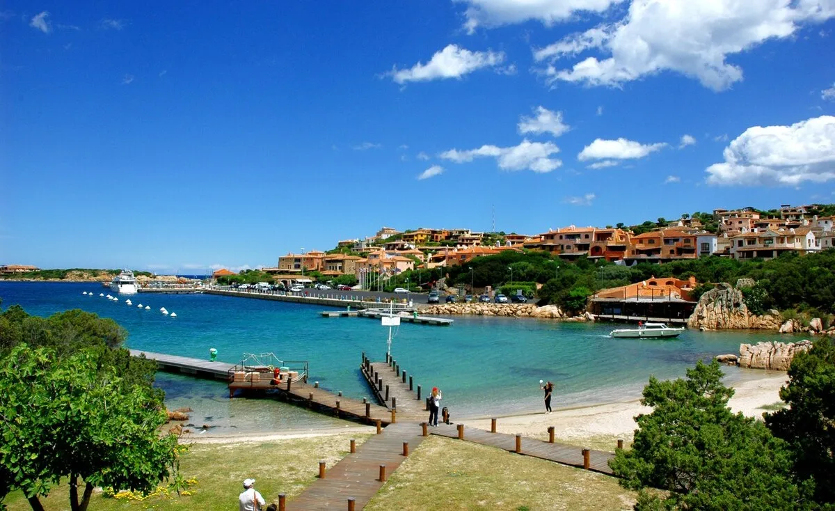 El puerto rodeado de casas de colores y con una pasarela de madera que se divide en tres que da directa al mar