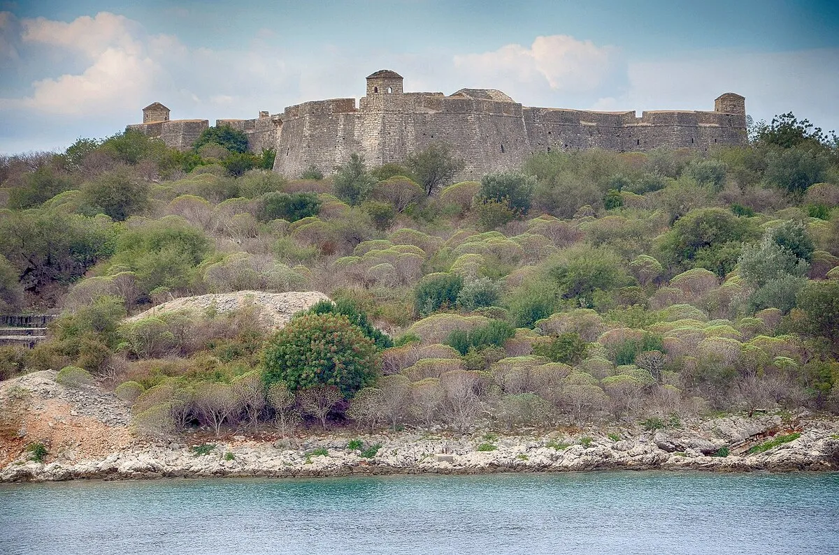 Vistas a la fortaleza desde el mar con vegetación frondosa rodeándola
