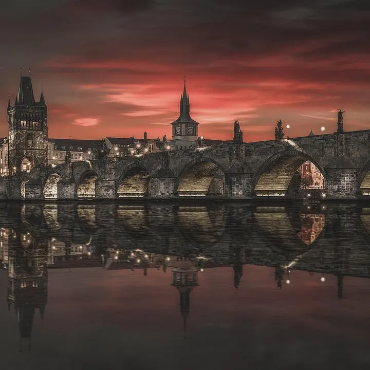 Panorámica nocturna del Puente de Carlos iluminado, Praga.
