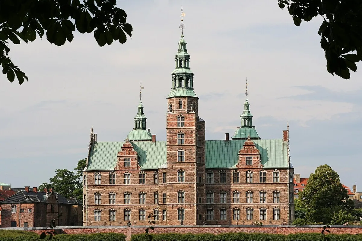 Panorámica del palacio de estilo barroco danes rodeado de arboles y casas