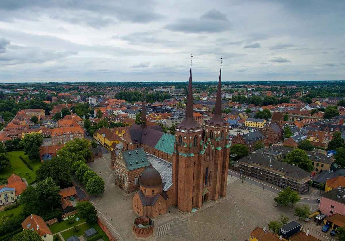 La catedral de Roskilde vista desde el cielo y rodeada de casa de colores.