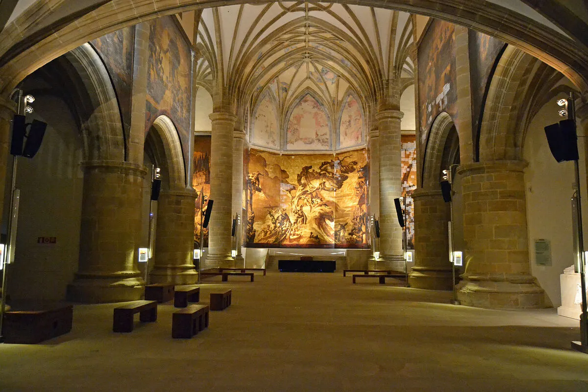 Interior del museo con columnas y arcos de medio punto de piedra