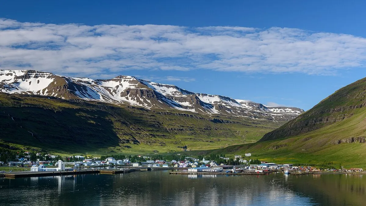 Las casitas del pueblo en las orillas del Oceano Atlántico con las montañas al fondo repletas de nieve