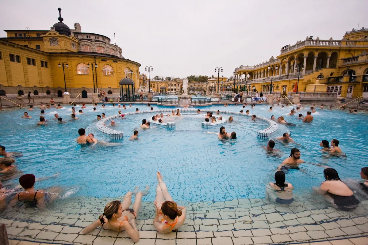 Panorámica del balneario durante un día soleado con gente en las piscinas bañandose.