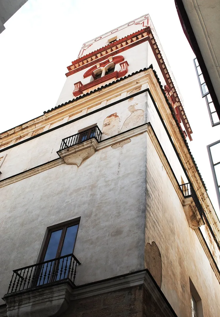 La torre blanca con detalles rojos vista desde abajo en una foto contrapicada