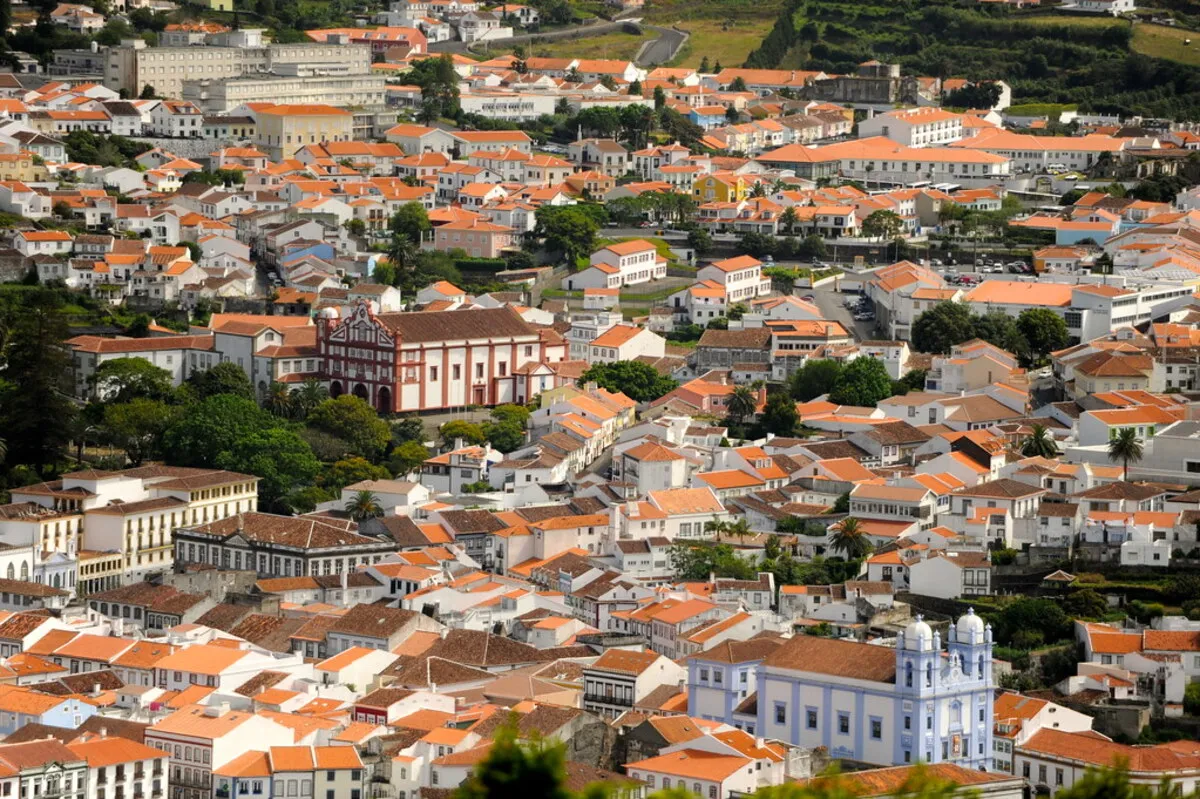 Vista panoramica de la preciosa ciudad con casas blancas con tejados naranjas y la catedral con detalles azules.