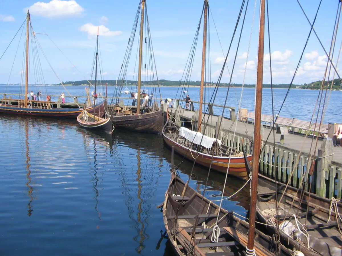 Barcos vikingos anclados en el puerto que se encuentra en el fiordo durante un día soleado
