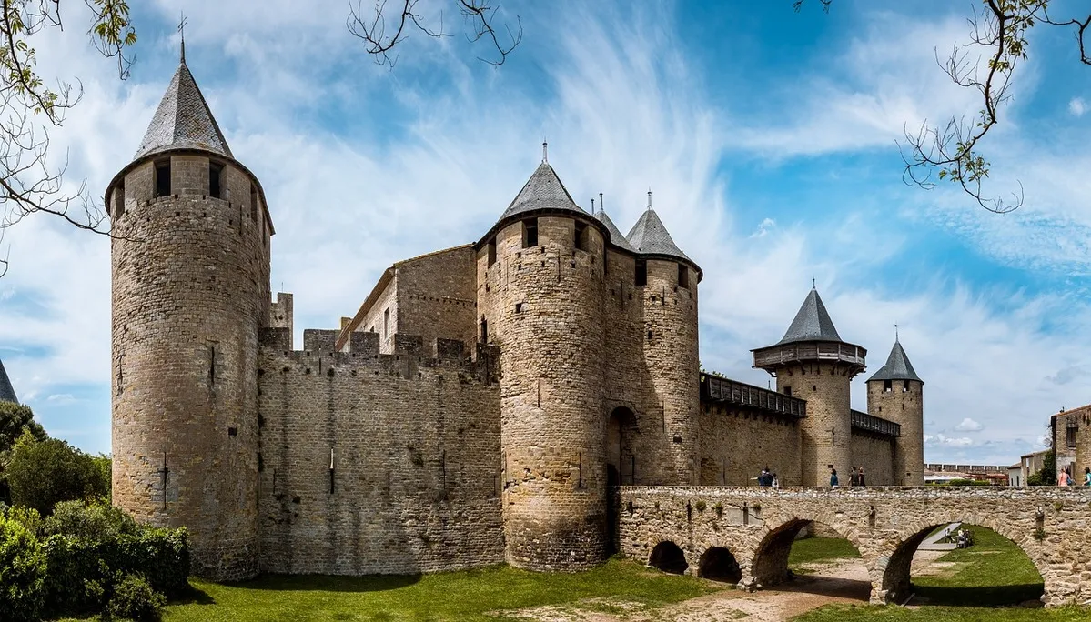 Una fortaleza medieval con un puente de piedra atravñés del cual se puede acceder