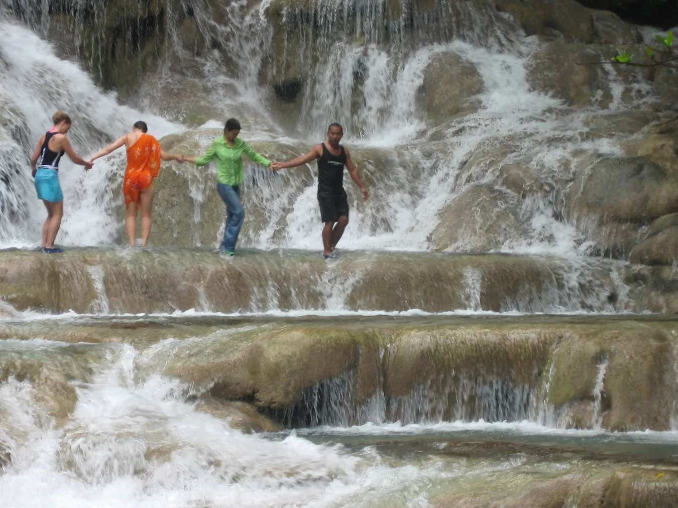 Gente haciendo una cadena humana para subir por las cascadas del Dunn.