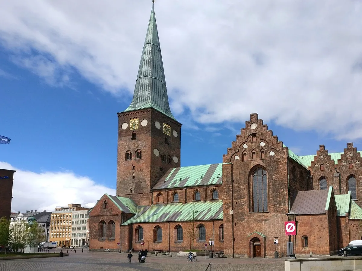 Uno de los lados de la catedral de estilo gótico con ladrillo rojo y techos verdes