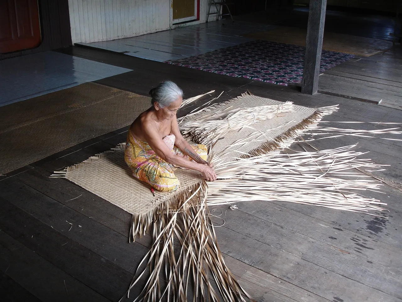 Mujer local tejiendo una cesta.