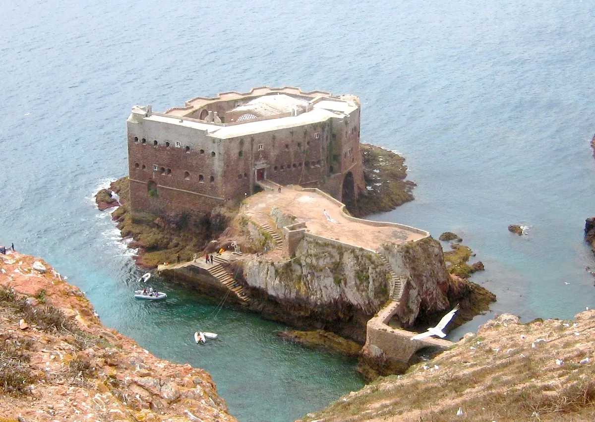 Vista panorámica del fuerte de São João Baptista rodeada de agua con pequeños barcos