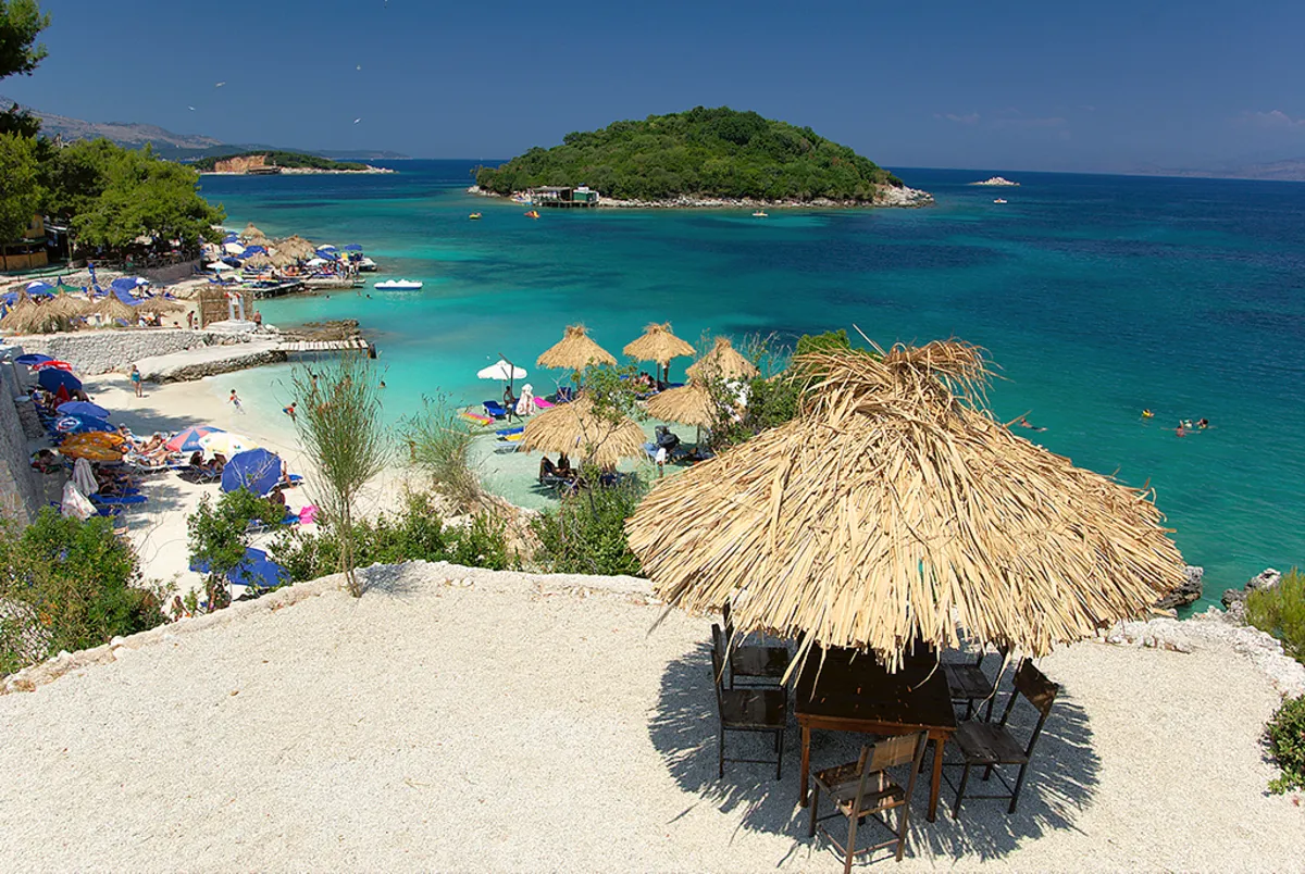 Vistas a una de las playas de la Riviera Albanesa desde uno de los miradores, con sombrilla de paja