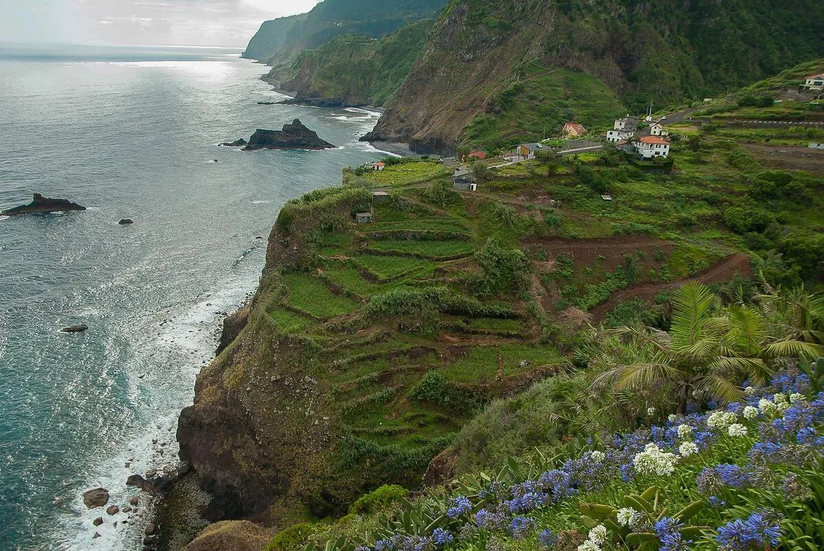 Uno de los acantilados de la isla, lleno de campos verdes y frondosos con casas de una aldea al fondo