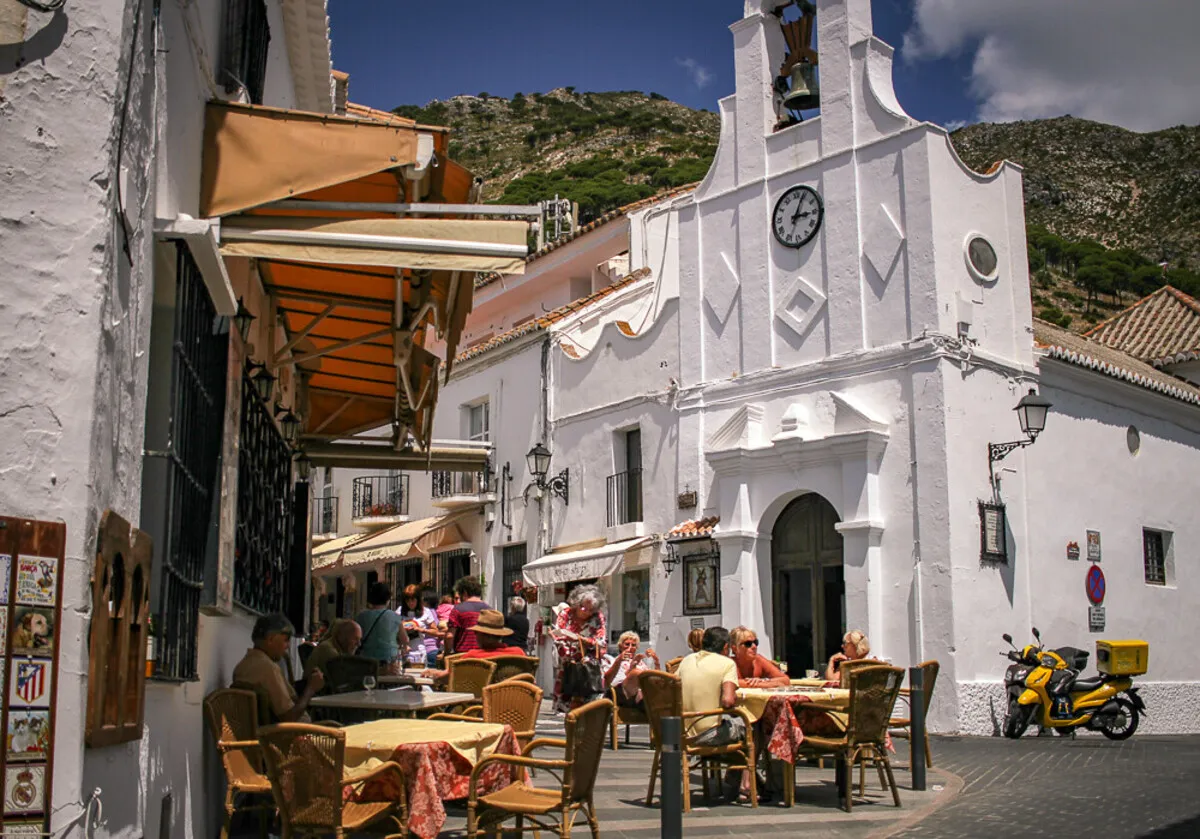 La plaza principal del pueblo con la preciosa iglesia blanca, el campanario arriba y terrazas donde la gente toma algo