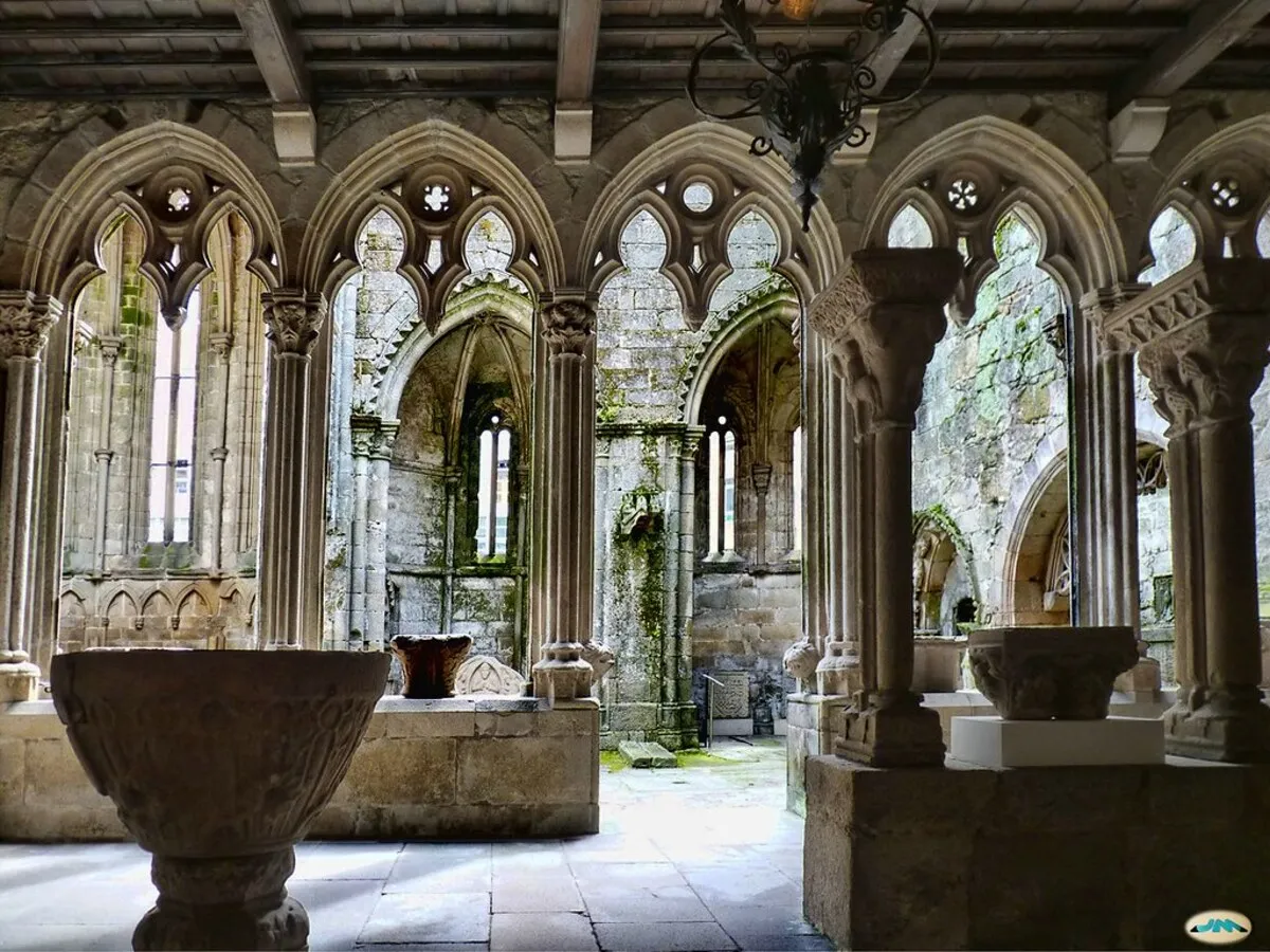 Interior de las ruinas con preciosos arcos góticos y mo verde por las paredes de piedra