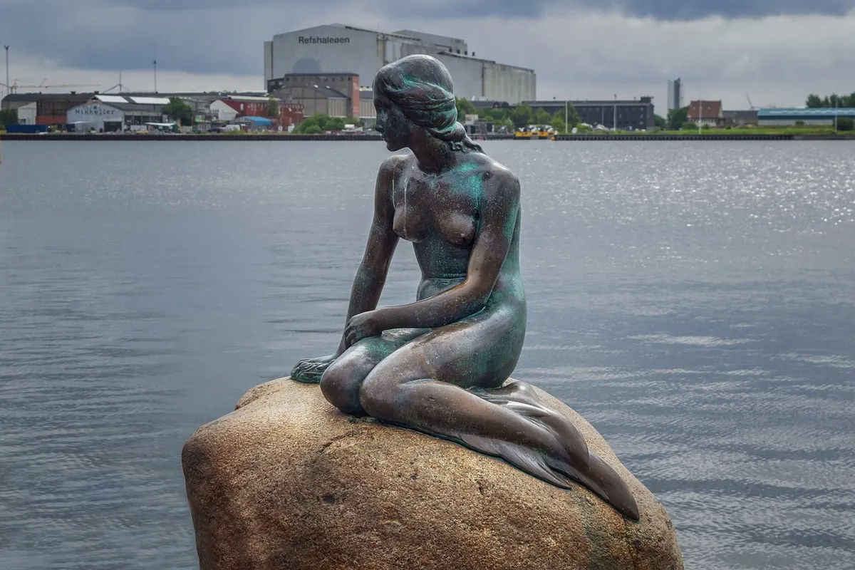 la estatua de la famosa sirenita de Copenhague sobre una roca en el mar