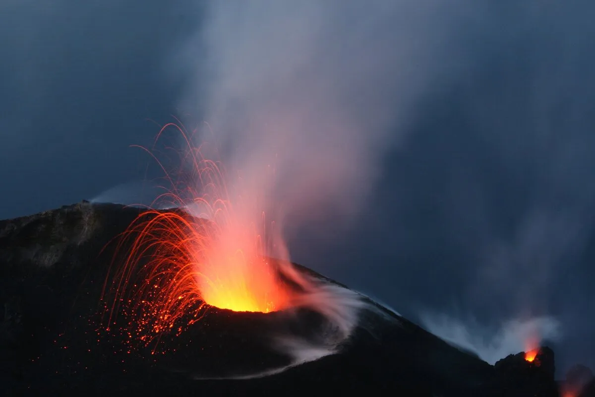 Volcan en erupción con humo y fuego brotando del cráter